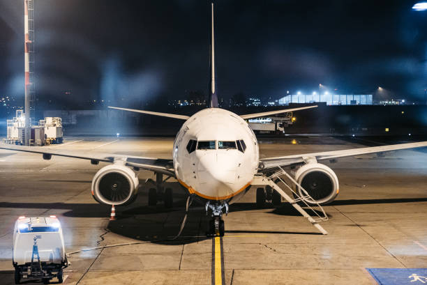 A plane on the airport terminal at night.