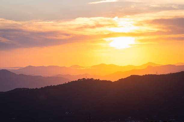 Landscape view of a colorful sunset over the hilly terrain in Tuscany, Italy.