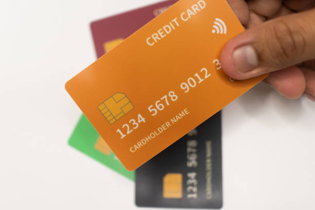 istock Orange Credit Card Held in Hand on White Background. 2181300471