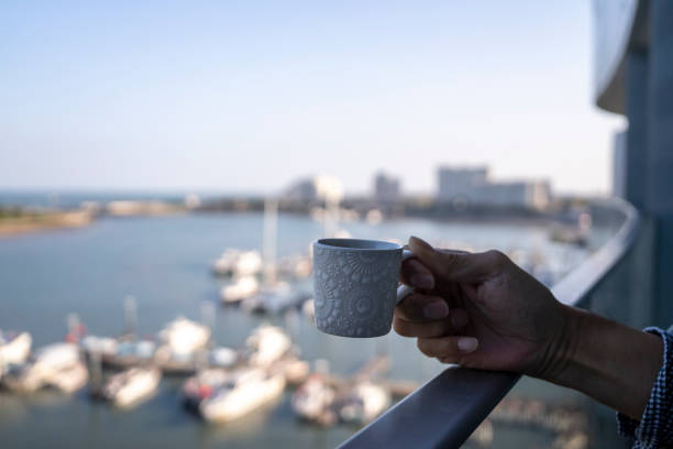 man holding cup of coffee on balcony