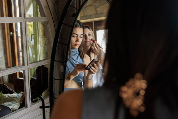 istock Female friends applying make up at home 2181302762