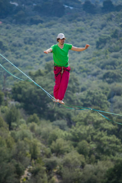 istock A tightrope walker walks along a cable stretched over a canyon. 2181306321