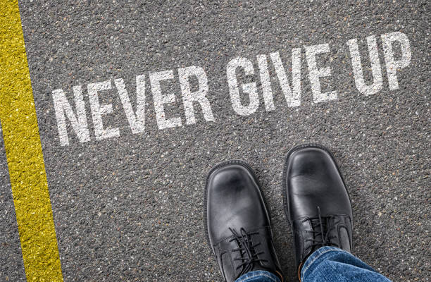 istock Text on the road - Never give up 2181309117