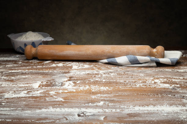 istock Pastry board with scattered flour and rolling pin on dark gray background. Space for text. 2181309309
