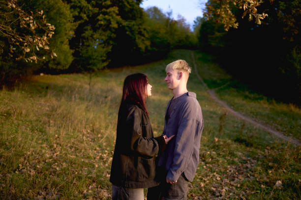 15-year-old teenage couple in love has an emotional fight in an autumn park A 15-year-old teenage couple in love has an emotional fight in an autumn park 13 14 years child teenage girls lying down stock pictures, royalty-free photos & images
