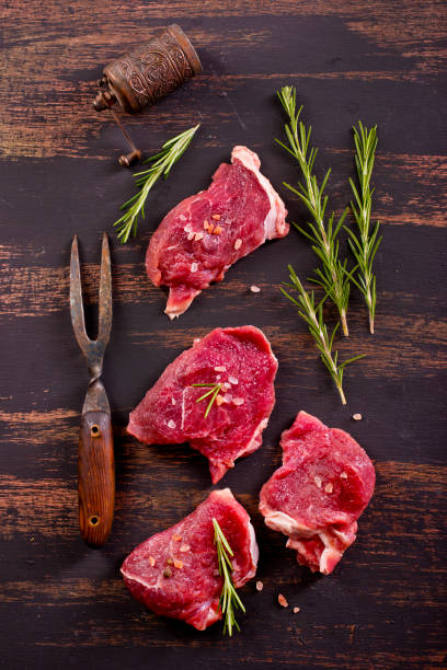 istock raw beaf on a dark wooden table. 2181310966