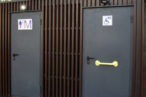 Doors to mobile modern toilet on street for people with disabilities and men, signs at entrance to public toilet with access for people with disabilities