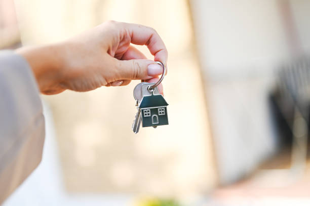 istock Real estate agent holding house key close up. 2181312316