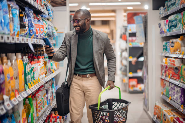 istock Happy Man Shopping in Supermarket Using Smartphone 2181313073