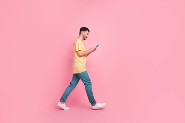 istock Full length profile side photo of positive man walking empty space using modern device gadget isolated on pink color background 2181313075