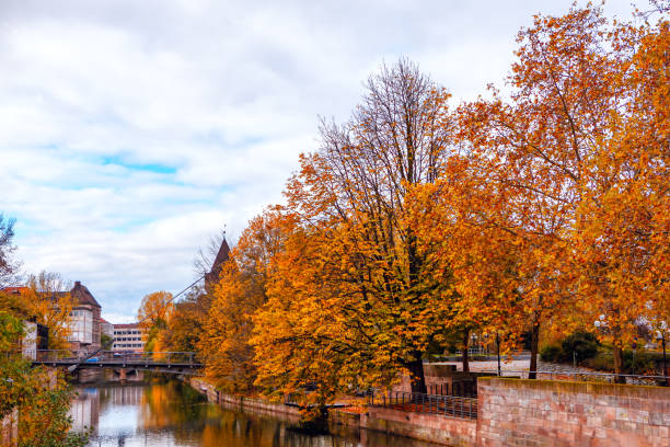 Autumn in Nuremberg, Serene river Pegnitz scene featuring a bridge. Weltherz fur Liebesschlosser
