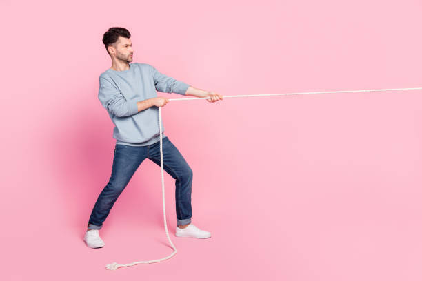 istock Profile side full body photo of guy pulling string have victory motivation isolated on pastel color background 2181313339