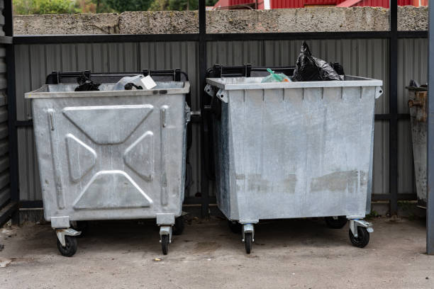 istock The image shows two metal garbage containers lined up together, filled with various types of waste and recycling materials in an outdoor waste disposal area 2181315368