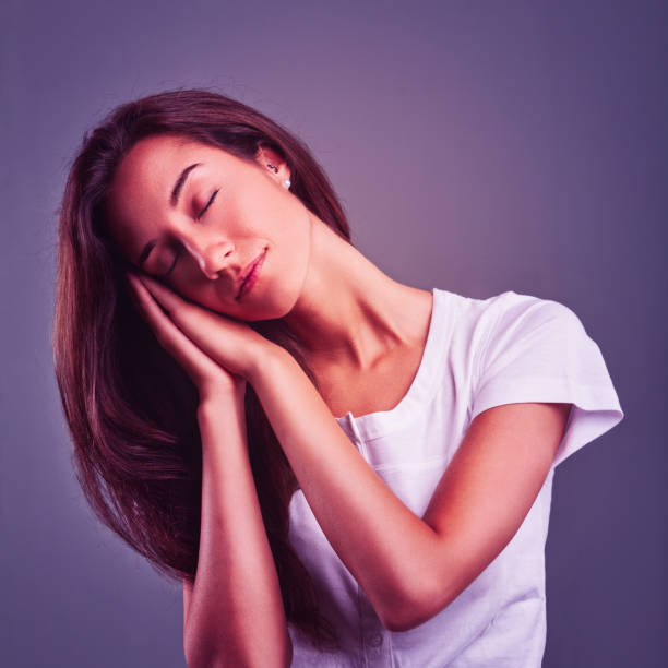 istock Young woman sleeping peacefully with hands on face 2181316266