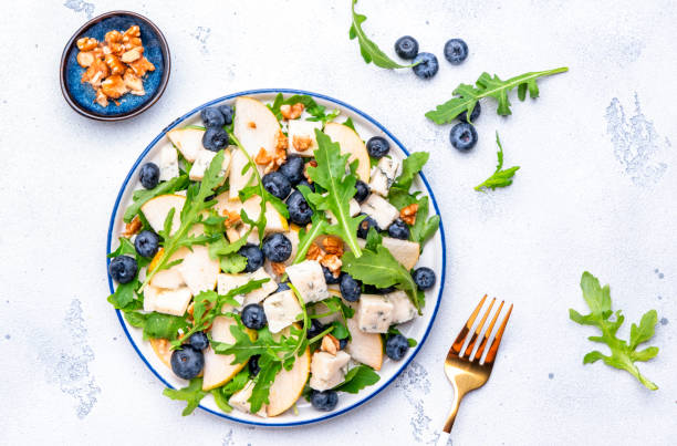 istock Salad with pear, blueberries, blue cheese, arugula and walnuts. White background, top view 2181317349