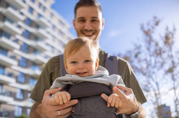 istock Smiling baby boy in carrier with father 2181317761