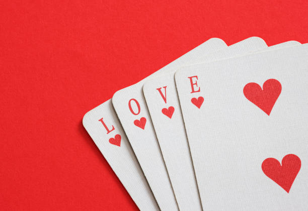 istock Four playing cards spelling love on red background 2181319032