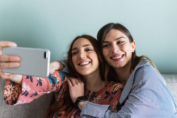 istock Smiling women hugging and taking selfie on smartphone 2181319587