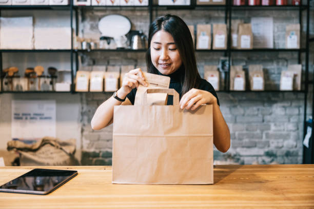 istock Female owner carefully prepares an online order for dispatch. 2181322190