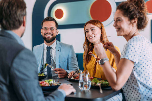 istock Happy business colleagues talking while eating lunch in a restaurant. 2181322417