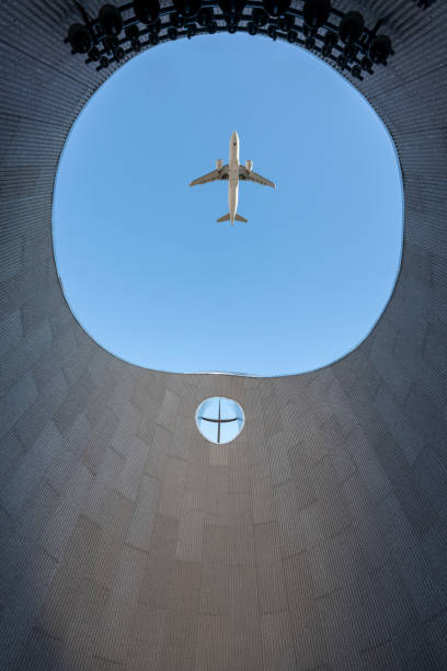 istock Airplane flies over the three-dimensional wall of modern building 2181323913