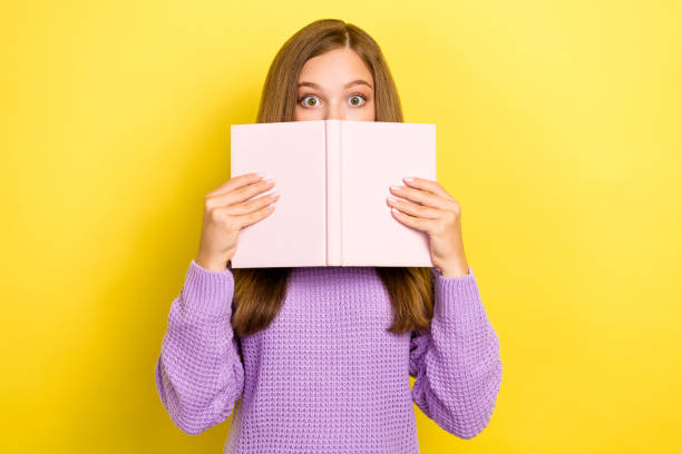 istock Photo of afraid scared lady hold planner book cover her face hide eyes avoid ignore teacher question isolated on yellow color background 2181338177