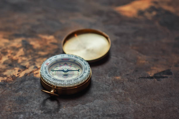 istock Retro brass compass in large on vintage background. Navigation tool for tourism. 2181338523