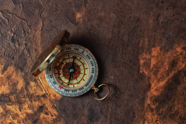 istock Retro brass compass in large on vintage background. Navigation tool for tourism. 2181338526