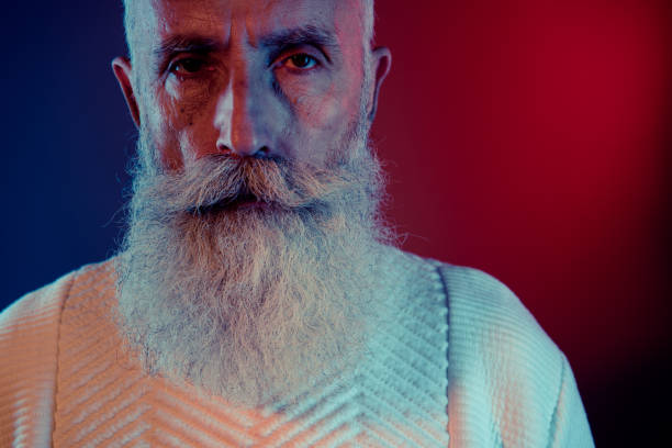 Photo of attractive groomed retired man dressed white pullover empty space isolated dark red blue color background.