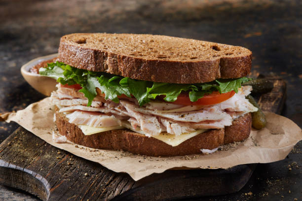 Left over Roast Turkey and Swiss Sandwich with Lettuce, Tomato, Grainy Mustard on Dark Rye Bread