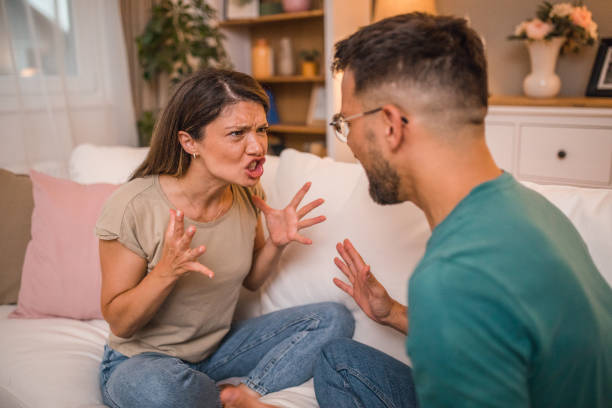 istock A man and a woman yell at each other while arguing at home 2181363477