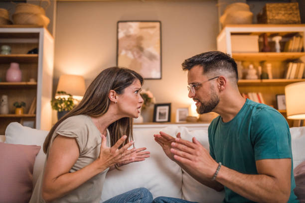 istock A married couple has a passionate argument while sitting on the sofa in the living room 2181363648