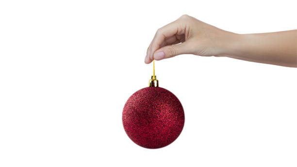 istock A woman's hand holds a red shiny Christmas tree ball isolated on white background 2181364986