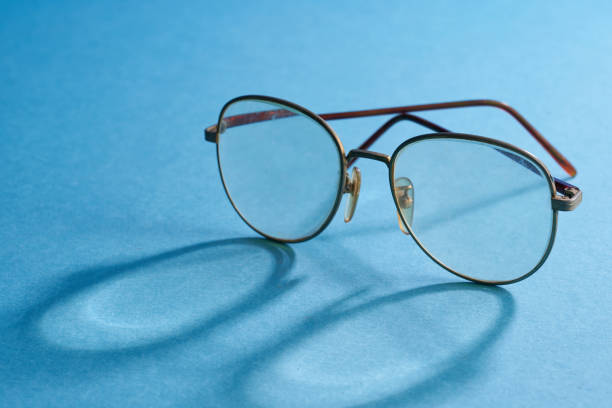 istock old golden reading glasses against blue background 2181365410