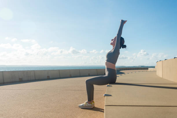 istock sporty woman doing a seated arm stretch exercise outdoors on concrete steps 2181366498