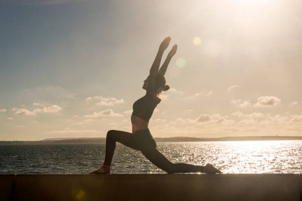 istock silhouette of a woman practicing yoga outdoors, low lunge 2181366558