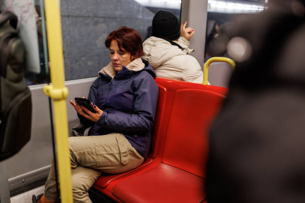 Mature woman riding in subway train at night