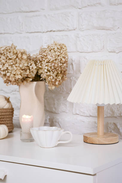 istock Autumn consept in interior.This arrangement features dried flowers, an elegant lamp, charming decor, pumpkins, cup of hot tea creating a cozy atmosphere. 2181376555