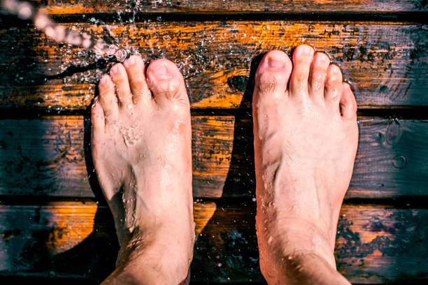 Feet getting wet from a sprinkler on a wooden deck