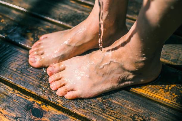 Woman's Feet on a Wooden Dock Getting Wet
