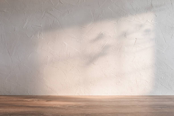 istock Soft sunlight casting gentle shadows on a textured wall and wooden surface in a minimalist kitchen setting 2181378788