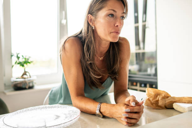 istock A contemplative woman is seen in a modern kitchen, deeply engaged in her thoughts and reflections 2181379008