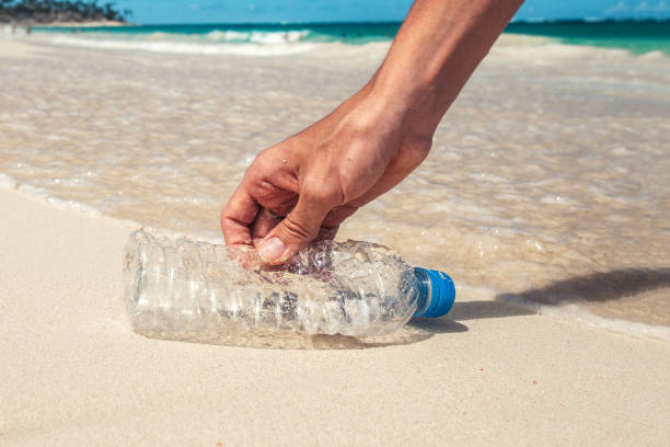 istock volunteer collects plastic bottles from the ocean shore 2181380363