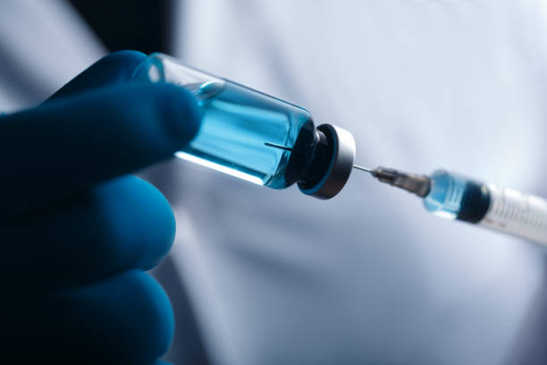 istock A blue-gloved medic's hand holds a syringe and test vaccine 2181381185