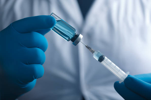 istock A blue-gloved medic's hand holds a syringe and test vaccine 2181381221