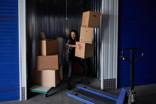 istock Woman carrying heavy boxes in container 2181381351
