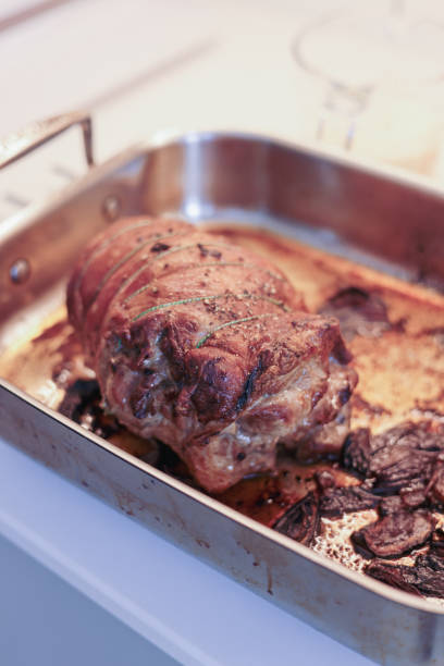 Roast Pork Loin Roll with Crackling. Christmas Pork tradition. Cooking over charcoal in a kettle bbq