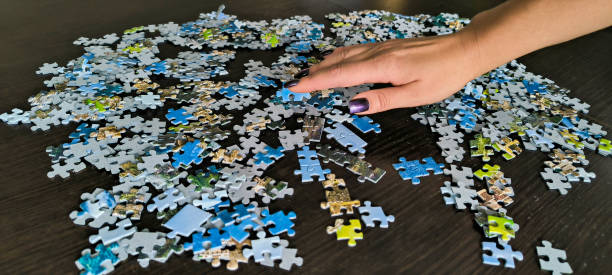 istock Girl assembling a mosaic. Assembling puzzles. A hobby for the soul. Development of fine motor skills of hands. Fun games for the whole family. Educational games 2181384982
