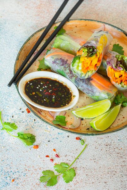 istock Fresh Asian appetizer Spring rolls (Nem) made from rice paper and raw vegetables and herbs with hot sauce on a light blue background. Vietnamese Food 2181388684