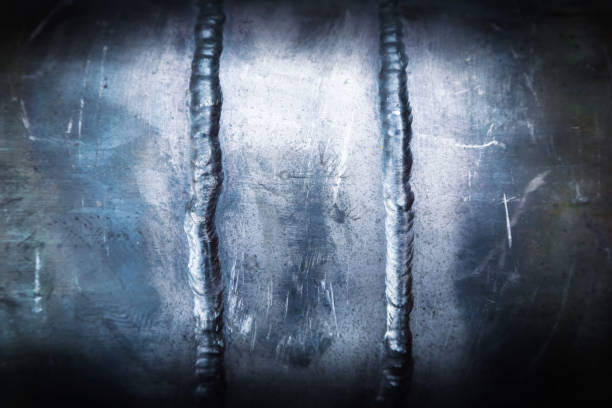 Two vertical welding seams on a steel pipe, close-up.